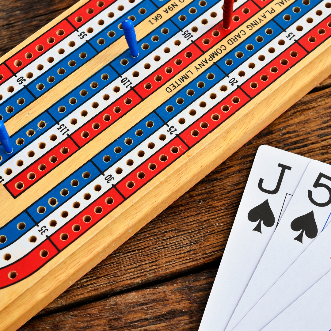 cribbage board and jack of spades and five of spades