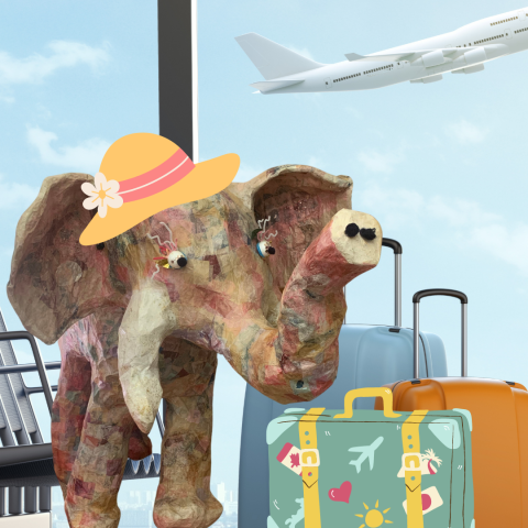 paper mache elephant in a sun hat at the airport with her luggage