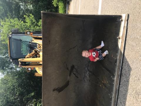 baby sitting inside a bulldozer