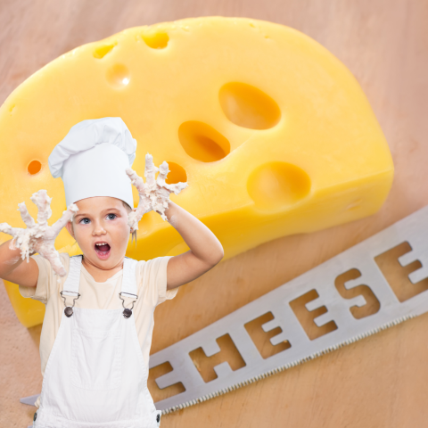 kid standing with cheesy hand in front of a block of cheese with the word cheese on a cheese knife. cheese.