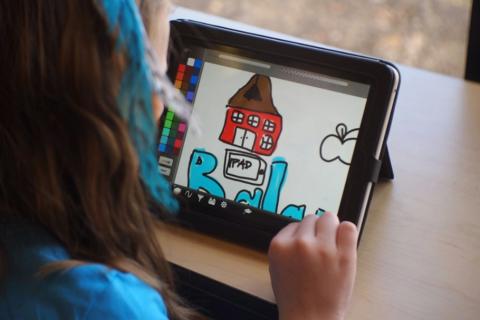 Child drawing on tablet. 