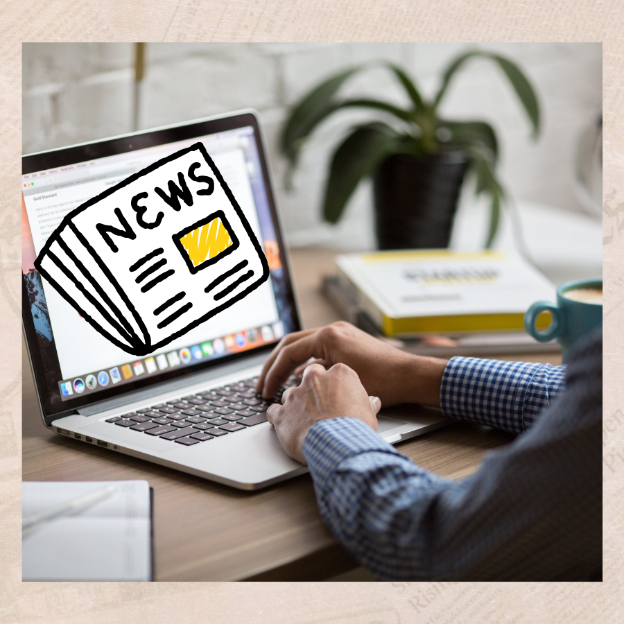 person on laptop with newspaper