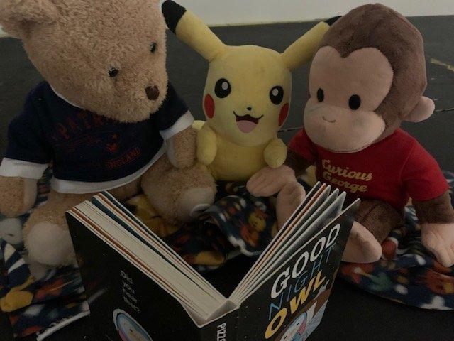 stuffies reading a book together